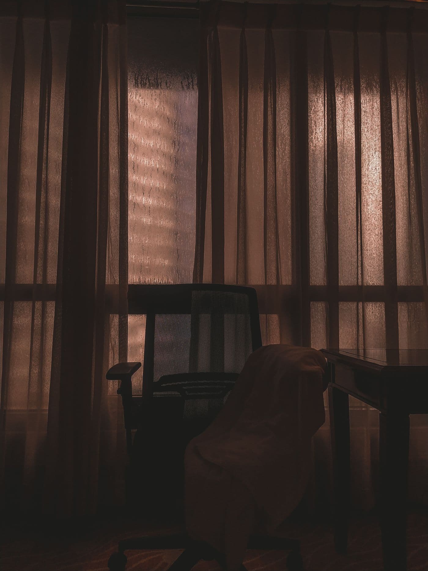 Bureau vide en fin de journée, lumière dorée, veste sur la chaise