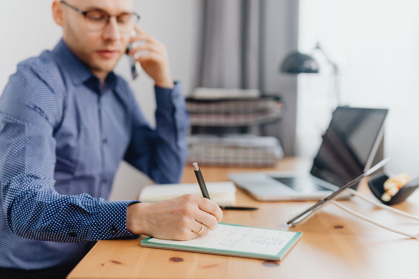 Commercial au téléphone, carnet de notes, CRM ouvert